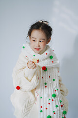 Young girl enjoying a treat in a cozy outfit.