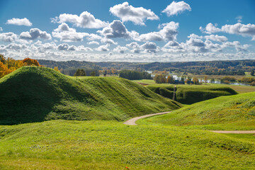 Scenic view of rolling grassy hills and a winding walking path in Kernavė, Lithuania
