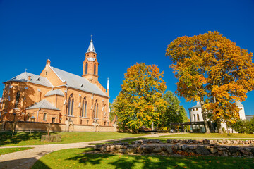 Neo-gothic brick church of Holy Virgin Mary Scapulary in Kernave, Lithuania, surrounded by vibrant...