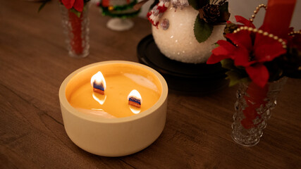candle with a wooden wick and Christmas objects around it