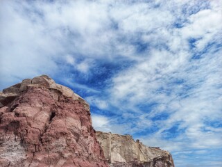 The rock cliff and cloudy blue sky
