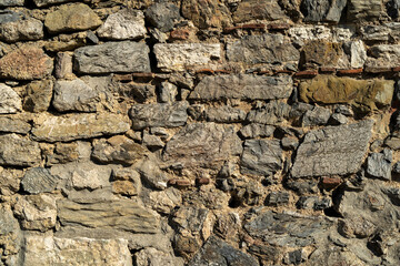 Textured stone wall composed of various sizes and shapes of rocks, showcasing natural colors and patterns, ideal for backgrounds or architectural design elements in creative projects