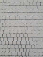 Fototapeta premium Texture of street tiles. Pattern of gray sidewalk tiles close up
