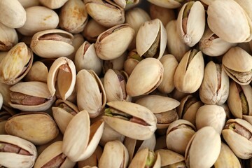 Many tasty unpeeled pistachios top view flat lay background pattern