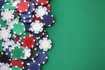 Casino gaming background with stacks of betting chips of different colors on green gaming mat
