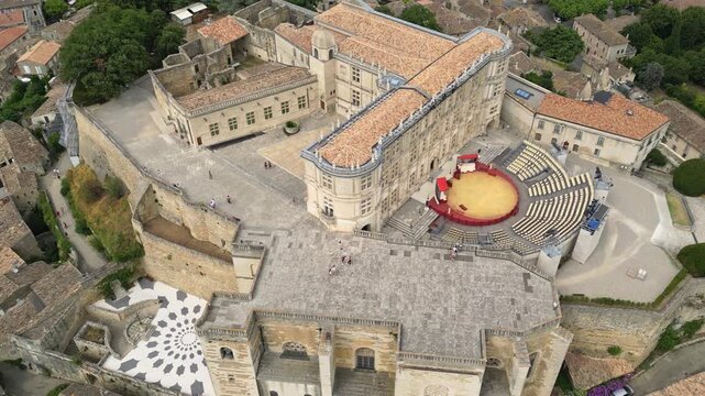 Aerial drone view of Grignan Castle surrounded by lush greenery and historic village in Provence, France &ndash; medieval fortress with scenic landscape and vibrant natural surroundings