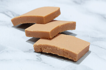 Handcrafted blocks of milk panelita cut on a marble surface, a typical Colombian sweet made from milk and sugar, an emblem of rural culinary culture