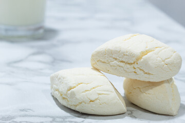 Colombian white biscuit-type cookies with a cracked homemade texture on a neutral background, evoking the tradition of neighborhood bakeries and the flavors of childhood
