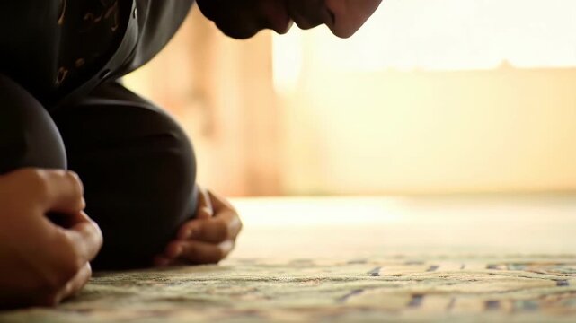 Muslim man praying prostrate on carpet in a mosque setting.
