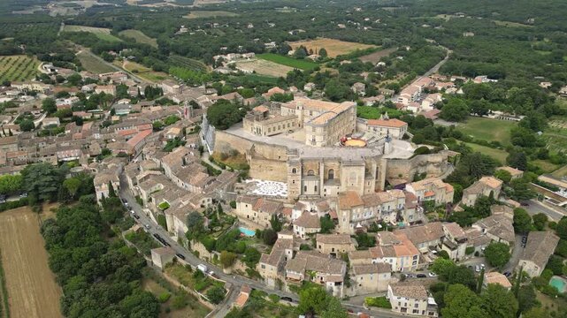 Aerial drone view of Grignan Castle surrounded by lush greenery and historic village in Provence, France &ndash; medieval fortress with scenic landscape and vibrant natural surroundings