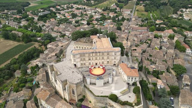 Aerial drone view of Grignan Castle surrounded by lush greenery and historic village in Provence, France &ndash; medieval fortress with scenic landscape and vibrant natural surroundings