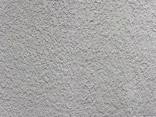 Gray concrete wall showing rough textured surface creating intriguing pattern