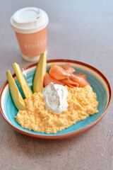 Delicious Breakfast Bowl Featuring Creamy Scrambled Eggs, Slices of Smoked Salmon, Crisp Avocado, and Accompanying Coffee for a Perfect Morning Meal