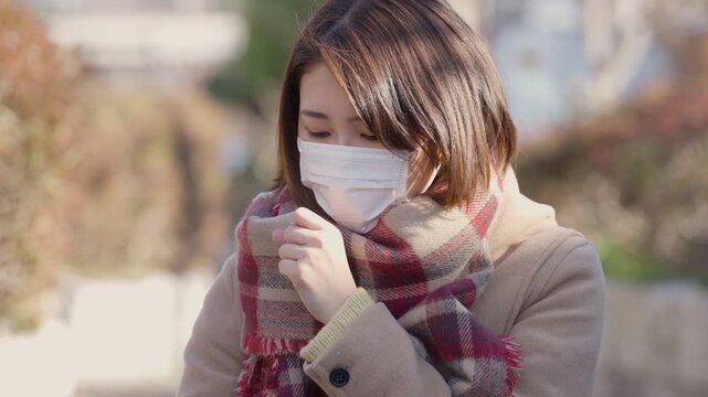 咳をするマスクをつけた女性