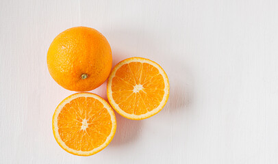 Top view of Halved orange fruit on white wooden background
