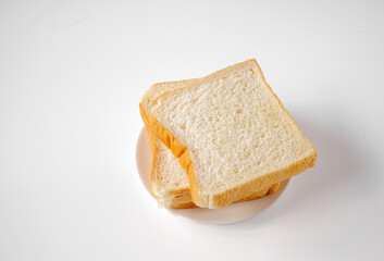 White sliced bread stacked on the white wooden table, top view