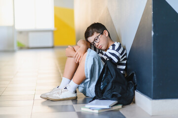 Schoolboy crying on floor after bullying incident