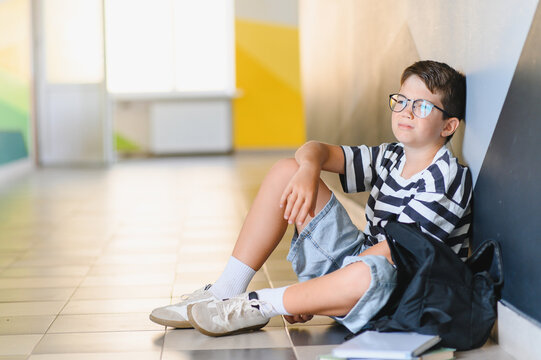 Sad schoolboy crying on floor after bullying from classmates - Powered by Adobe