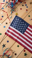 Obraz premium American Flag Surrounded by Festive Stars and Colorful Streamers on Wood Surface