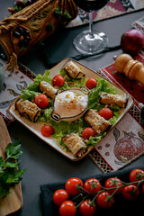 Deliciously Plated Eggplant Rolls with Fresh Tomatoes and Creamy Sauce on a Vibrant Green Bed of Lettuce Surrounded by Decorative Table Setting