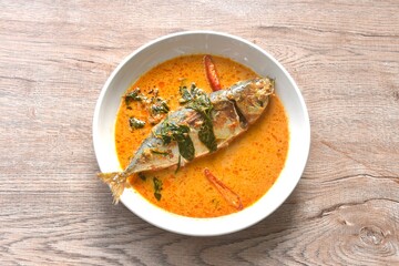 spicy boiled mackerel topping chop lemon grass in red curry sauce on plate 