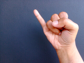 Male hand showing little finger. making promise gesture. isolated on black background. Space for text