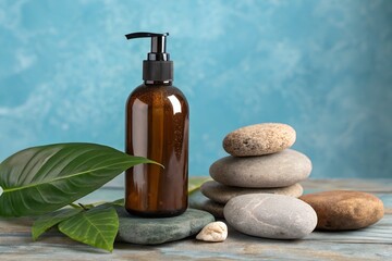 Brown bottle with pump and stone stack on wooden table against blue wall
