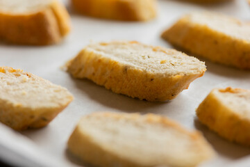 slices of bread in a tray ready to bake crostini close up