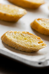 slices of bread in a tray ready to bake crostini close up