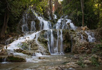Obraz premium Peaceful waterfall in a Croatian national park surrounded by lush greenery and clear water. A stunning natural landscape ideal for travel, nature, adventure, and outdoor-themed content.