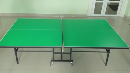Professional green table tennis setup in indoor facility perfect for recreational sport activities and competitive training - Powered by Adobe