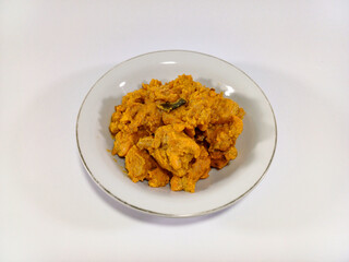 A plate of Chicken Salted Egg, a rich, creamy, and flavorful dish, presented against a plain white background. Related to Southeast Asian cuisine, savory chicken dishes, modern flavorful fusion food