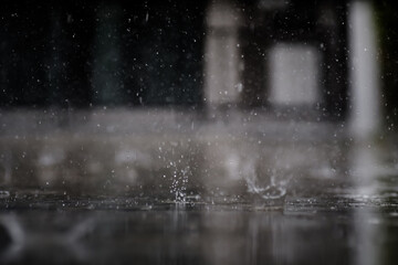 heavy raining make many small splash crown from water droplets drop down to the concrete floor in blue tone color scene