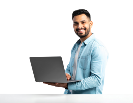 An attractive Indian man smiling and using a laptop on a white table, isolated on transparent background.