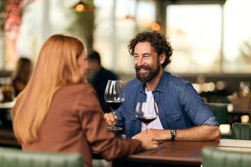 Cheerful Couple Enjoying A Romantic Dinner With Wine at a Cozy Restaurant