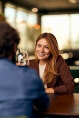 Smiling Woman Enjoying Conversation with a Friend at a Cozy Restaurant