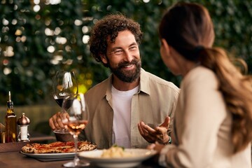 Happy Couple Dining at Outdoor Restaurant with Food and Wine