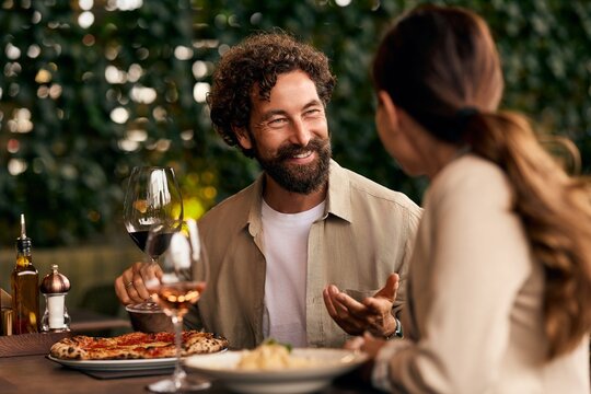 Happy Couple Dining at Outdoor Restaurant with Food and Wine