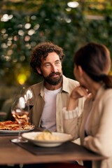Couple Dining at Cozy Restaurant with Wine and Italian Cuisine Outdoors