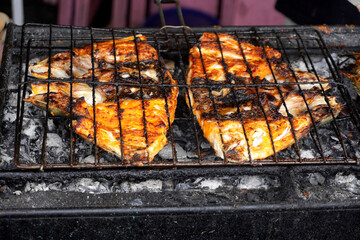 Succulent grilled fish sizzling over hot coals, perfect for summer barbecues and outdoor dining
