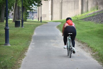 Obraz premium Woman riding a bike on path in East Hartford next to the Connecticut River 