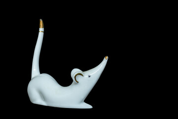Statuette of a white mouse on a black background