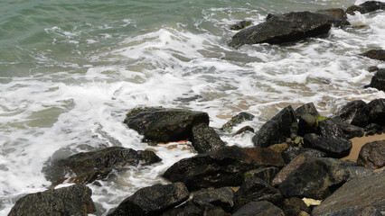 The foam of sea waves crashes on the rocks at Dhanushkodi beach in Tamil Nadu, India