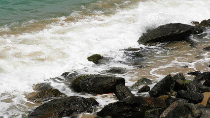 The foam of sea waves crashes on the rocks at Dhanushkodi beach in Tamil Nadu, India