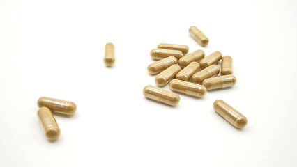 Herbal medicine capsules from herb powder on white background. 