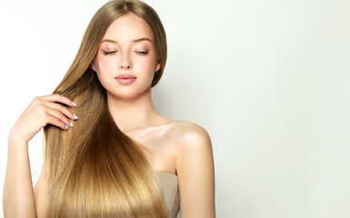 Beautiful model girl with shiny blonde and straight long hair . Keratin straightening . Treatment, care and spa procedures. Smooth hairstyle. 