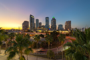 Night urban landscape of downtown district of Tampa in Florida, USA. American city skyline with brightly illuminated high commercial buildings and high speed highway road