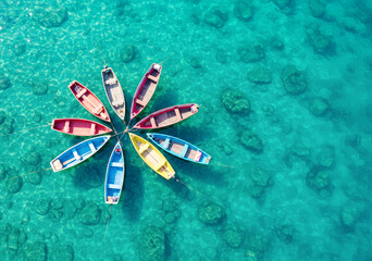 南国の澄んだ海を上空から撮影した写真。海に浮かぶカラフルなボート。