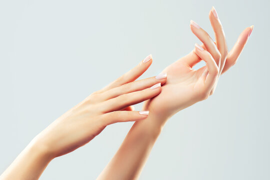 Hand skin care. Closeup of beautiful woman hands with  light manicure on nails . Cream for hands and treatment.