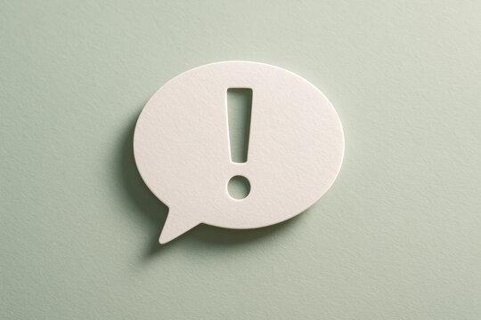 Exclamation symbol in white speech bubble with textured paper material conveys strong message and alert
